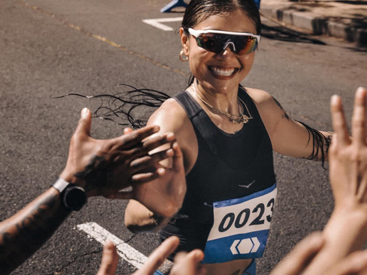 A smiling runner high 5s supporters during a race