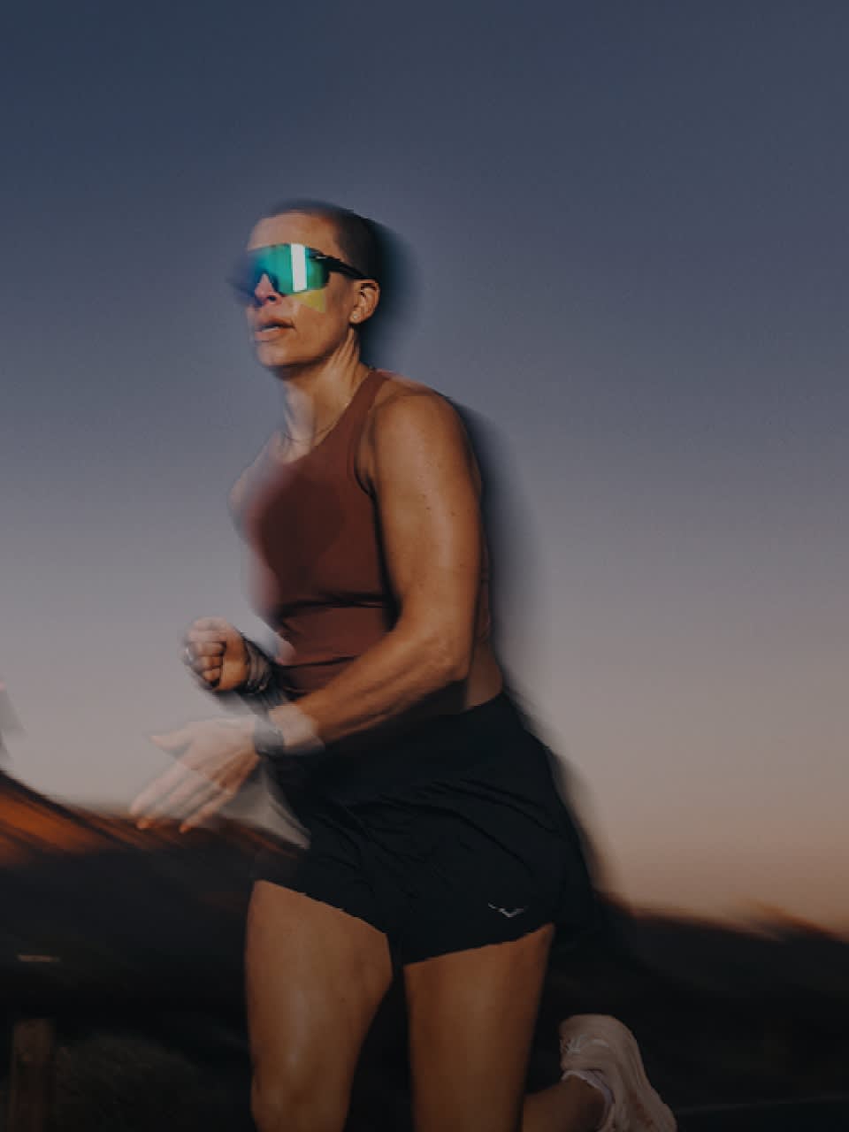 A person running in the dusk in sunglasses