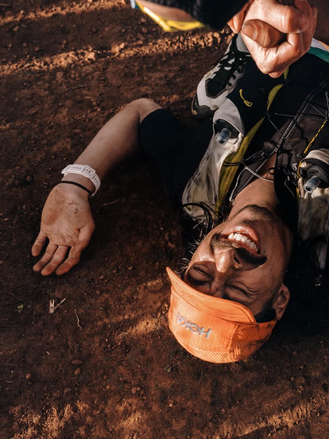 A person running on the trail in an orange hat