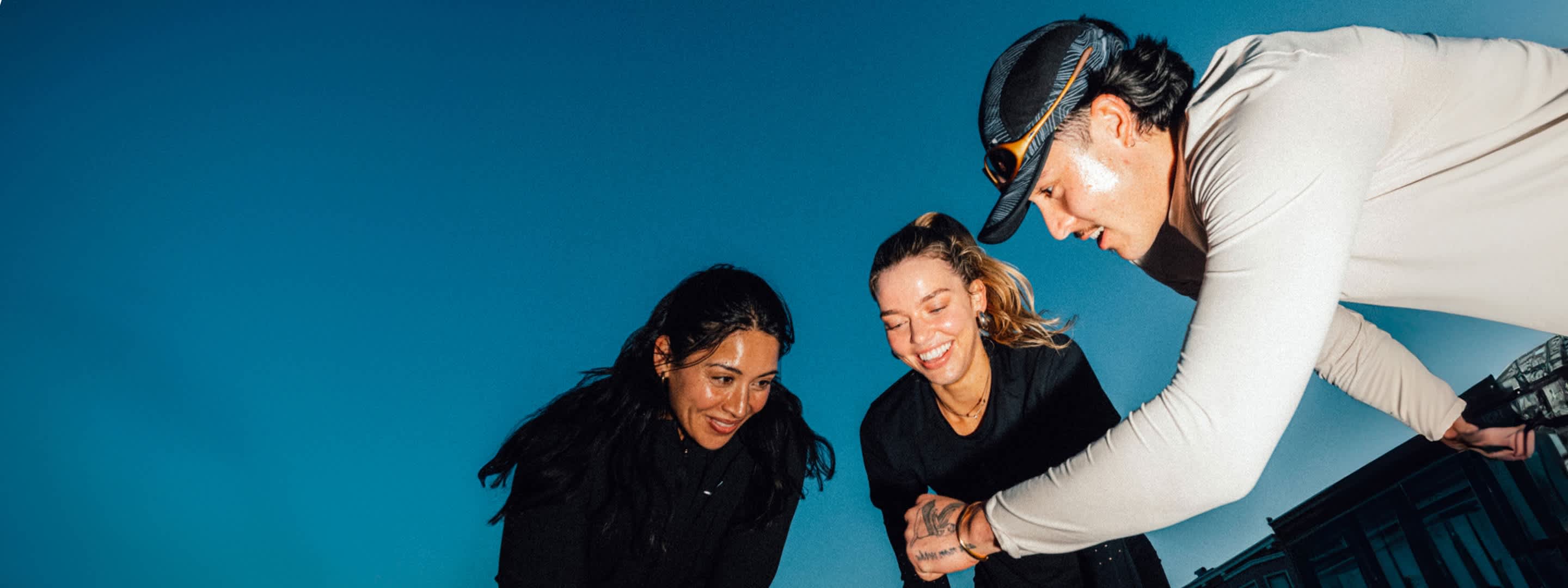 3 runners huddle together following an evening run.