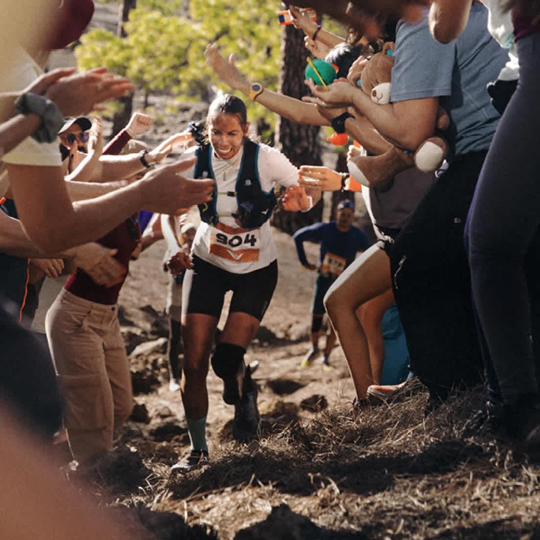 A person running through a crowd of people during a trail race