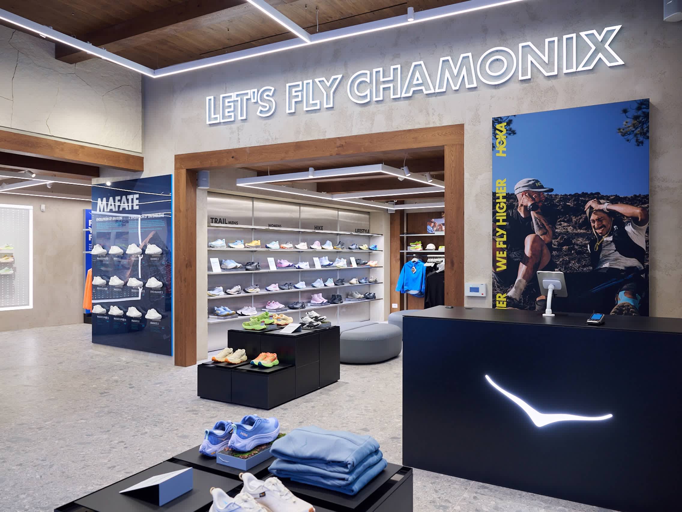 Hoka running shoe store interior featuring displays, branding, and wall signage.
