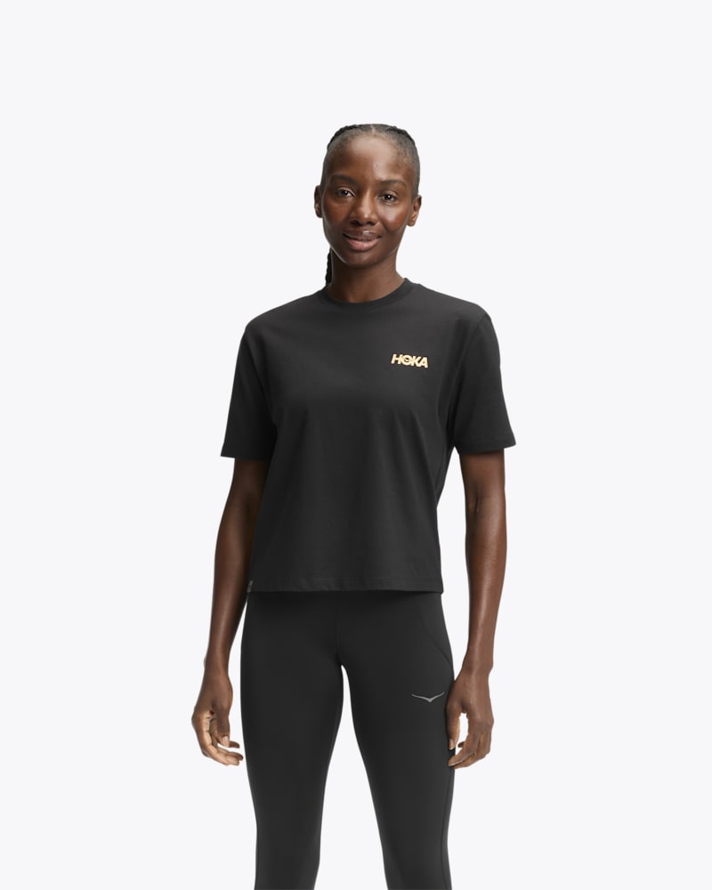Women's HOKA Manifesto Short Sleeve Tee Shirt in Black/Gold, Size Medium
