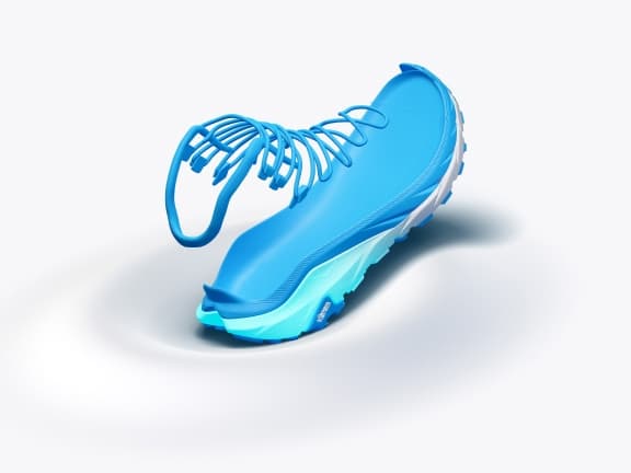 Abstract bright blue running shoe with skeletal laces on white surface.