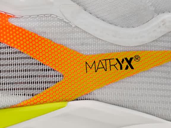 Close-up of shoe detail: orange, yellow honeycomb pattern, white fabric, "
                                        MATRYX®"