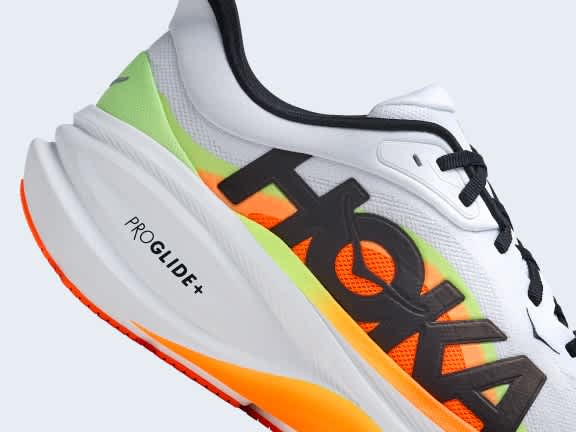 White Hoka running shoe, black logo, orange and neon green accents, PROGLIDE™+ 