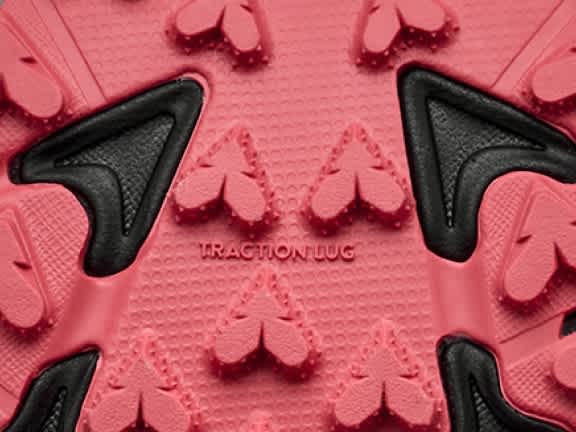 Pink and black shoe sole texture with clover-shaped and triangular traction lugs.