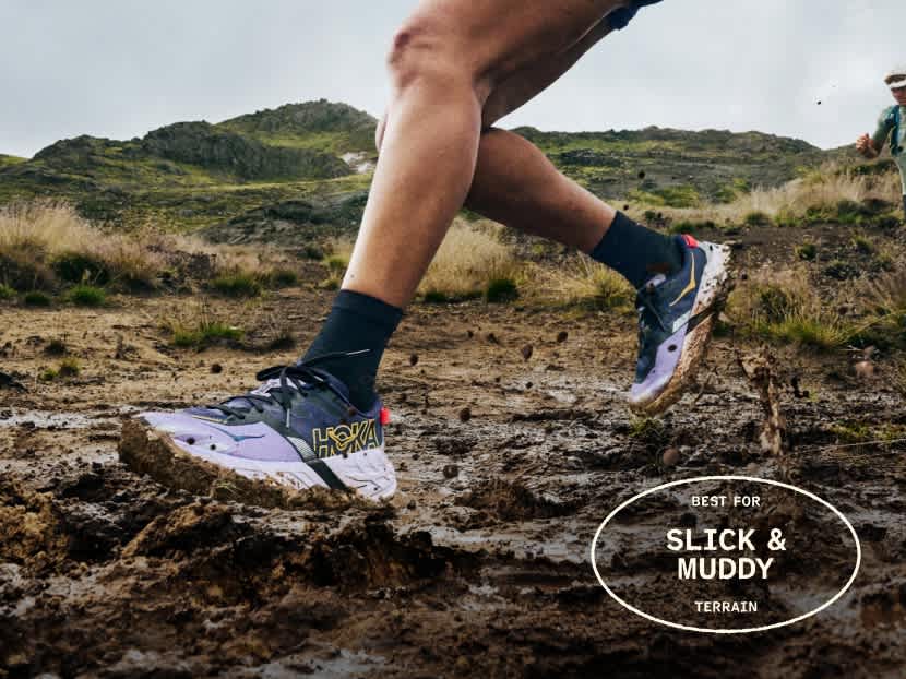 Person running through thick mud in trail shoes, splashing.