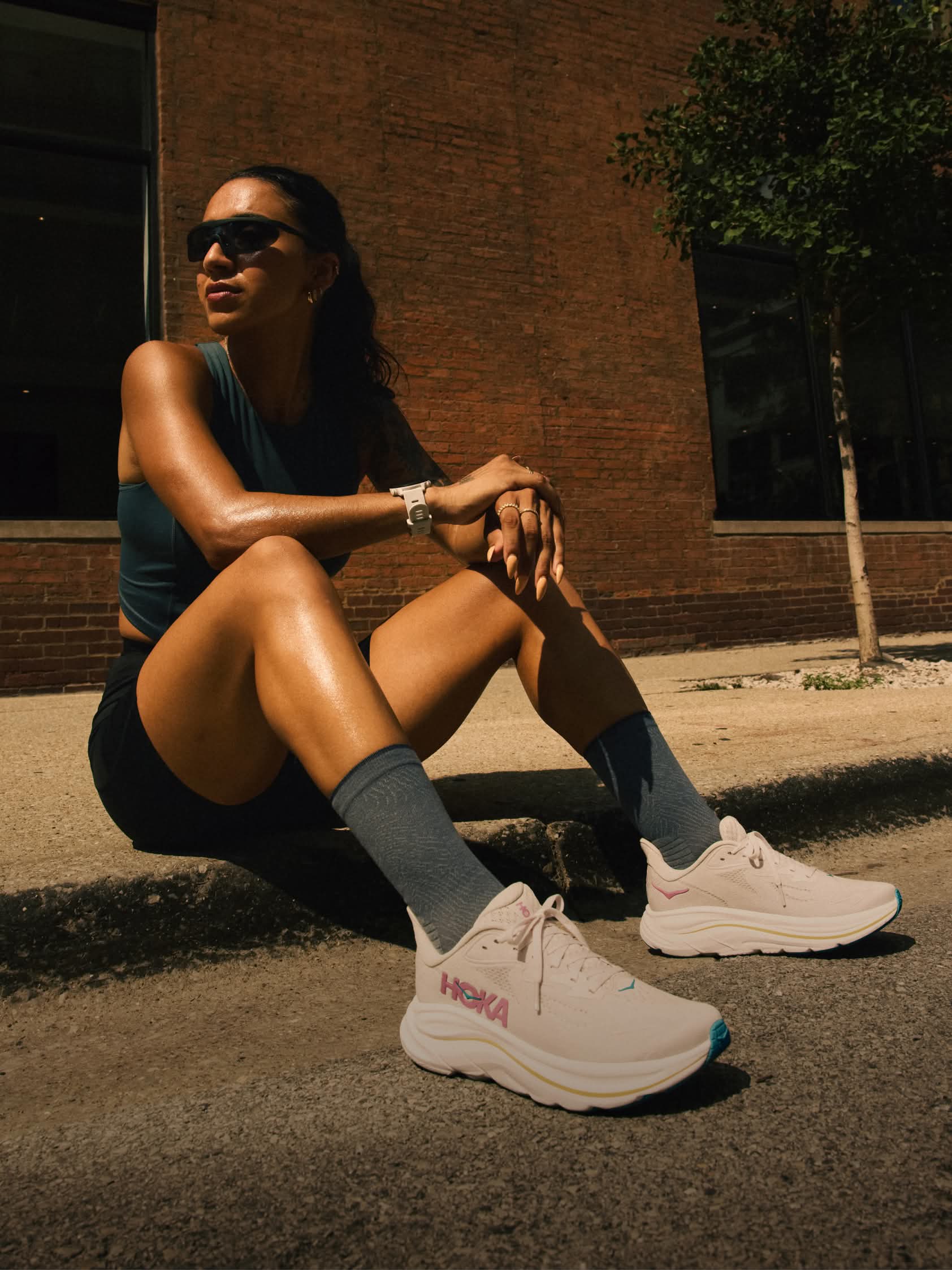 Campaign shot showing a female runner wearing the HOKA Clifton 10 running shoe.