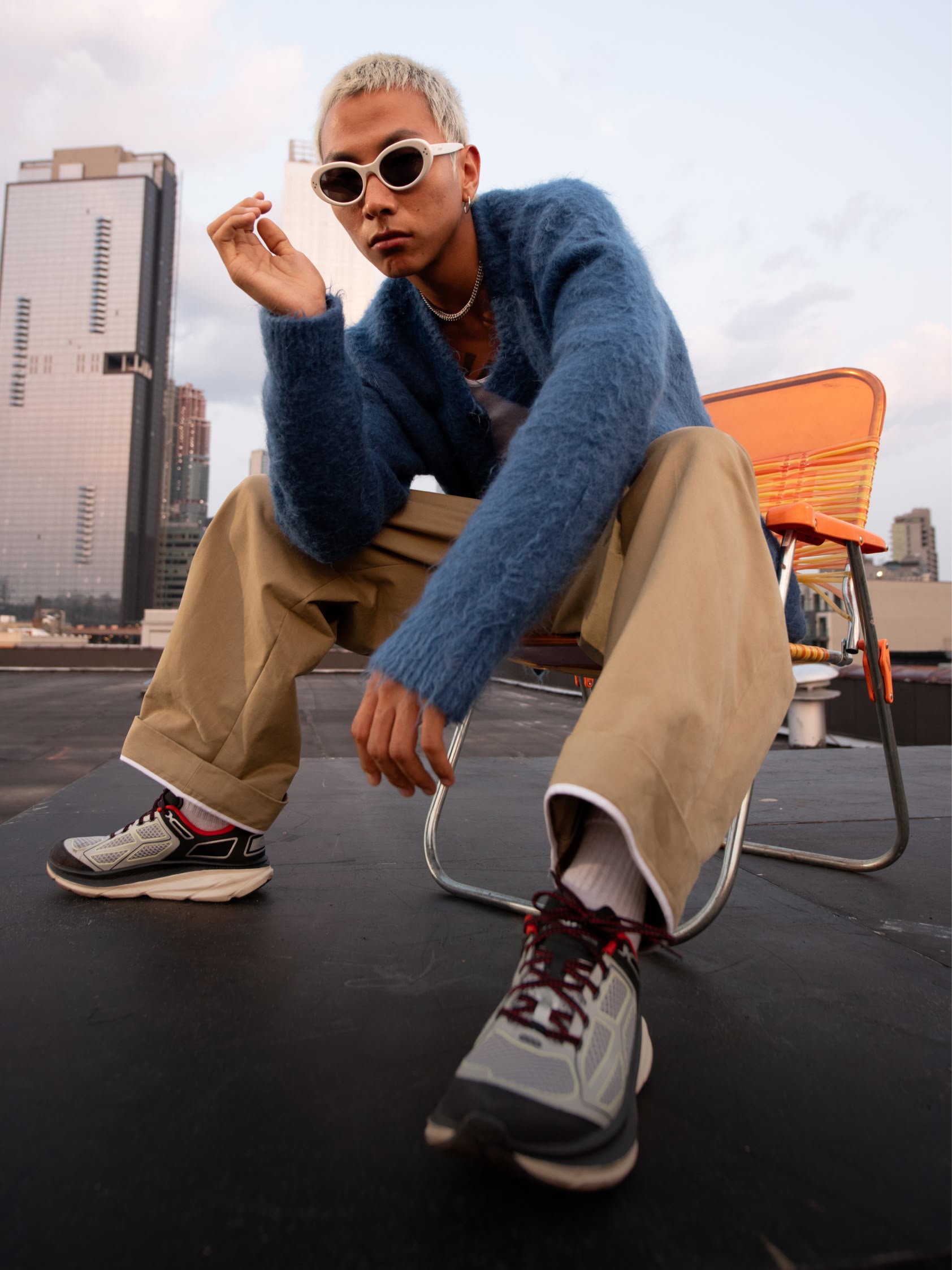 A model poses on a city rooftop wearing HOKA Clifton One9.