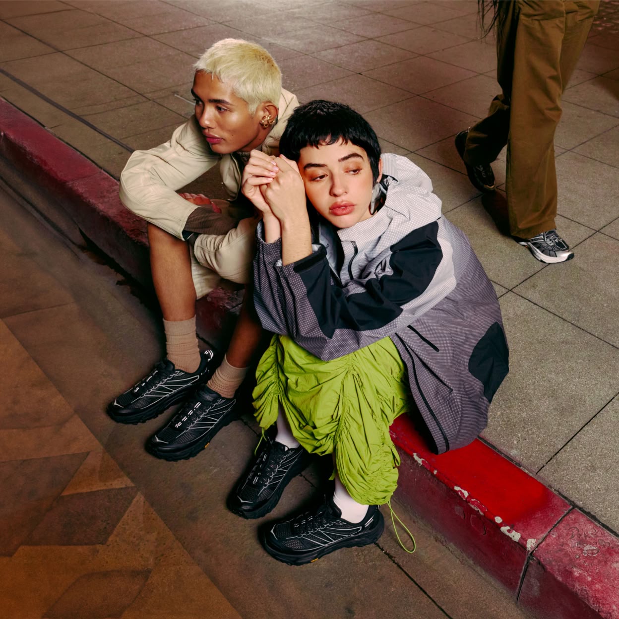 Two models pose on a step wearing HOKA STEALTH/TECH collection.