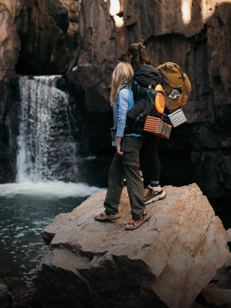 Two women walking by a waterfall Two women walking by a waterfall