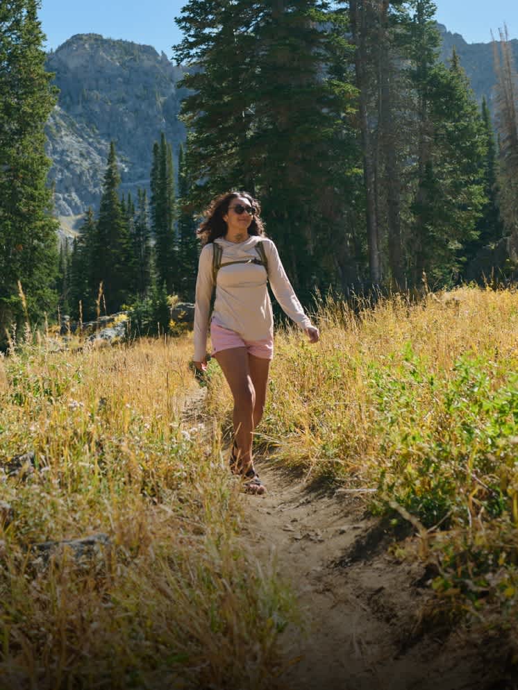 A girl walking through a field in Teva sandals A girl walking through a field in Teva sandals