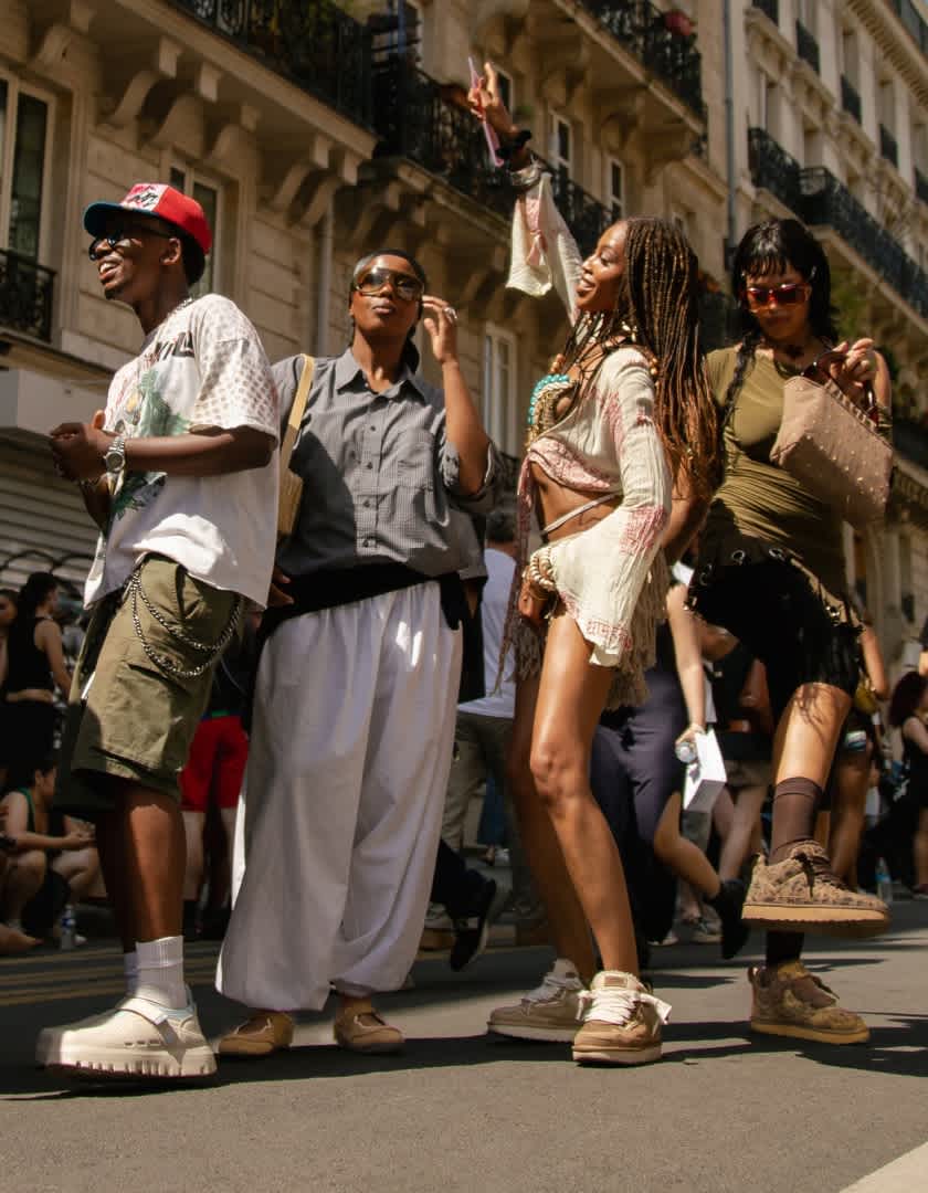 Group of people wearing casual footwear and summer clothing gathered on a city street.