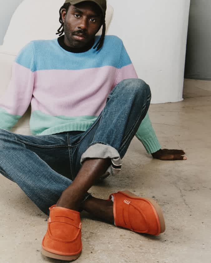 UGG JW Anderson loafers in orange styled with cuffed jeans and a colour-block knit.