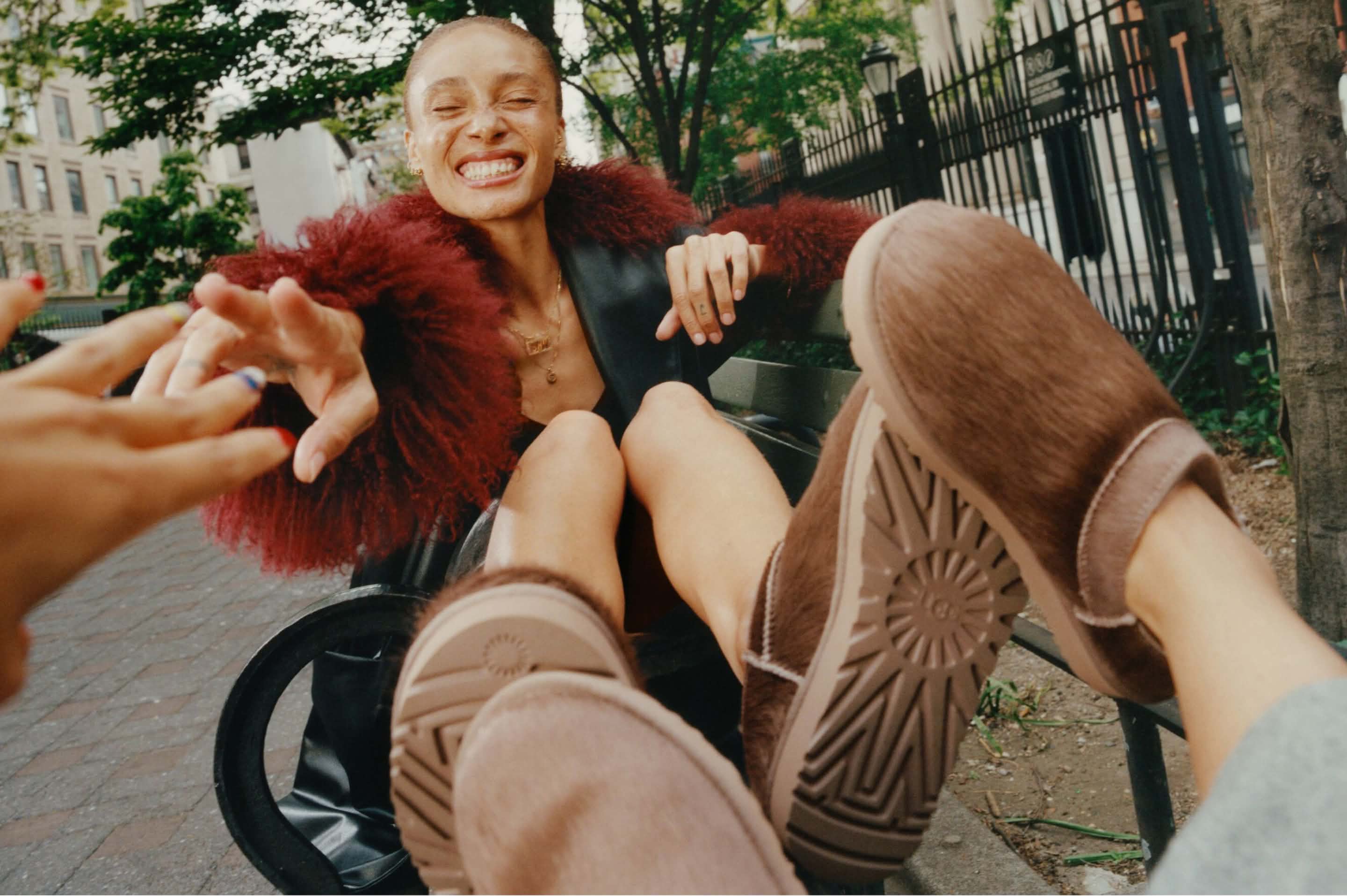 UGG brown suede clogs worn while relaxing on a park bench with friends.