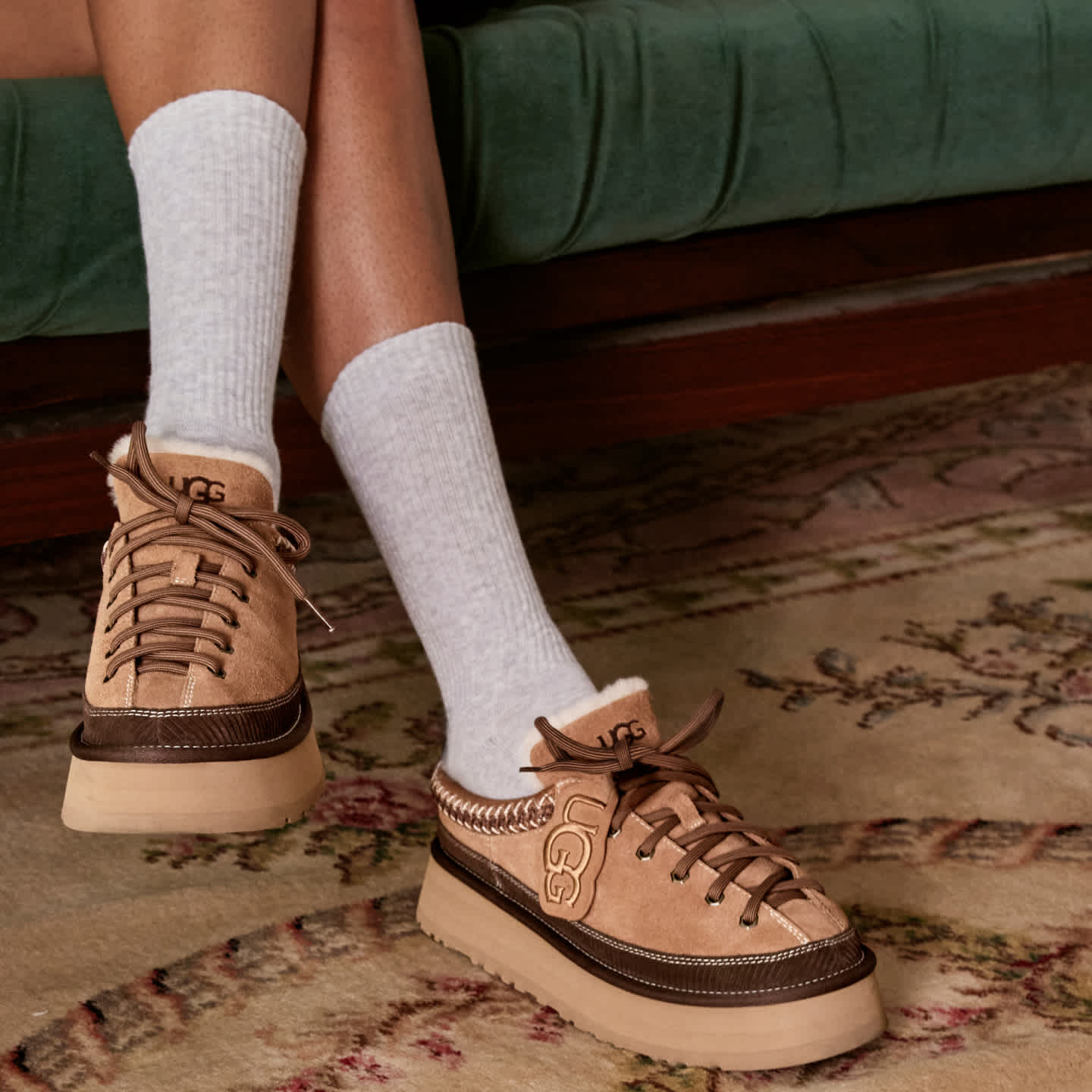 UGG Heritage Lace-up Slippers worn by person in grey socks, indoors on a rug.